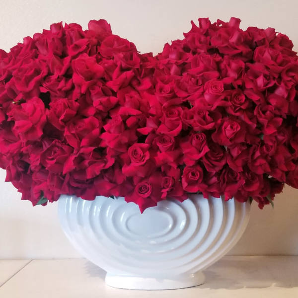 Large arrangement of red roses in a white vase