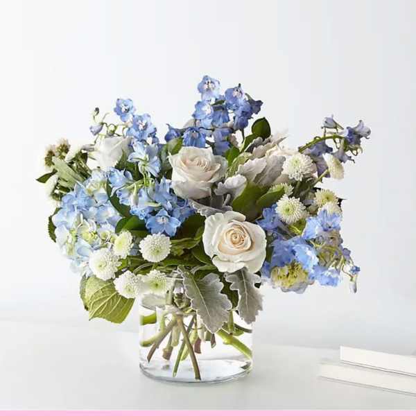 Blue and white flower arrangement in a clear glass vase