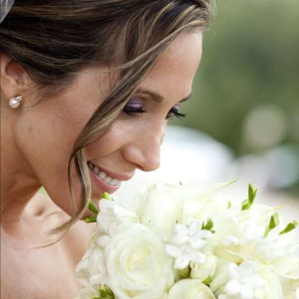 Bride holding a white bouquet of roses and small white flowers