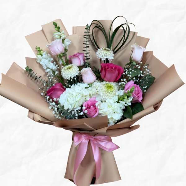 Bouquet of pink and white roses with hydrangeas in brown paper wrap