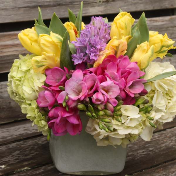 Colorful bouquet of tulips and hydrangeas in a gray vase