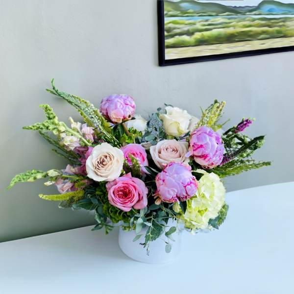Pink and white roses with hydrangea in a white vase
