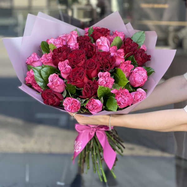 Bouquet of pink and red roses wrapped in lavender paper