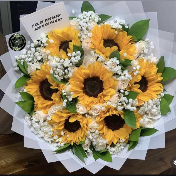 Bouquet of sunflowers, white roses, and baby's breath with a card
