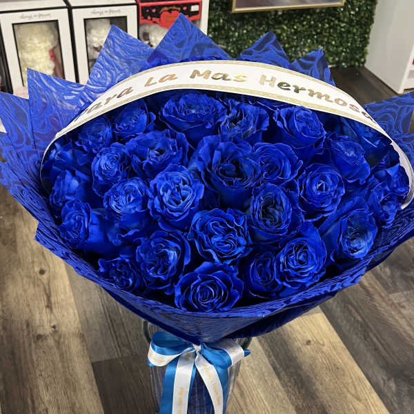Bouquet of vivid blue roses wrapped in blue paper with a ribbon
