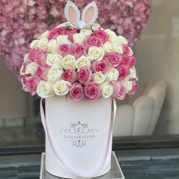 Pink and white roses in a white hatbox with bunny ears