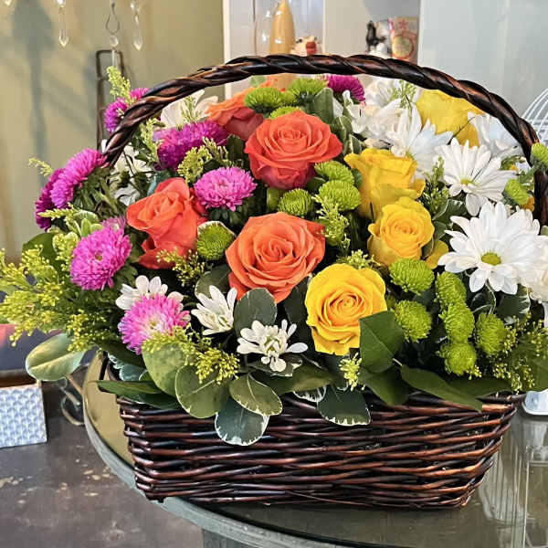 Basket of mixed roses and daisies in bright colors