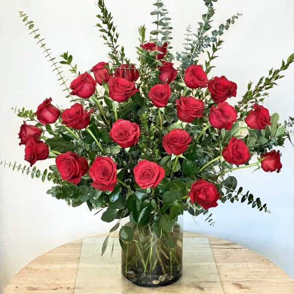 Tall bouquet of red roses in a glass vase