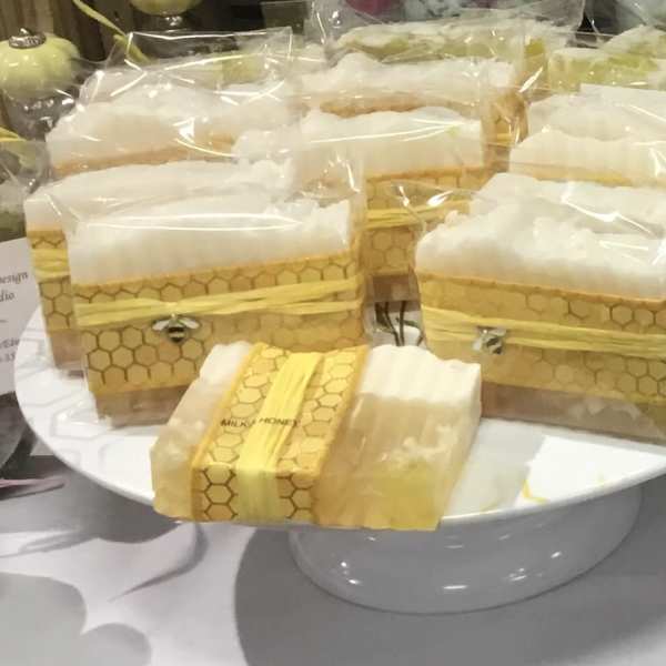 Wrapped honeycomb-pattern gift boxes on a white pedestal