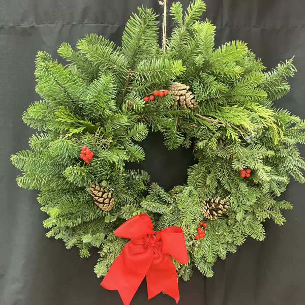 Evergreen wreath with pinecones, red berries, and a red bow