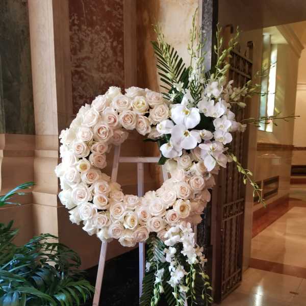 White rose and orchid wreath on a standing easel