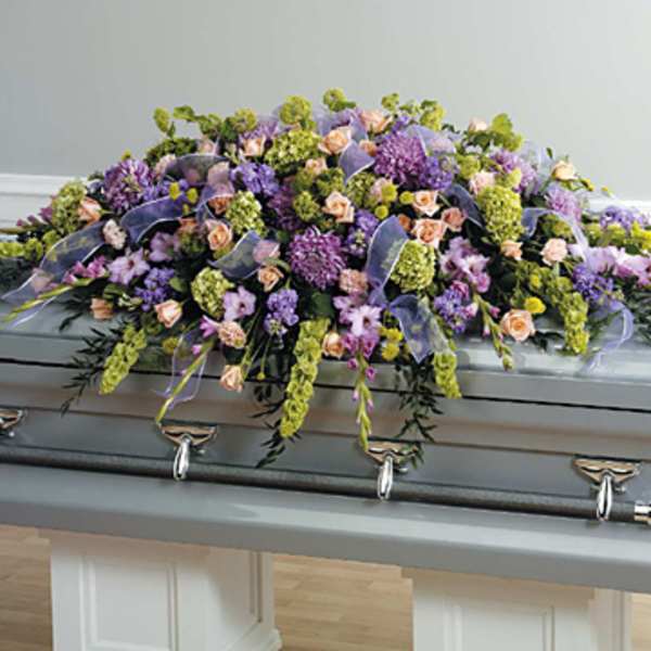 Lavender and peach floral spray on a silver casket