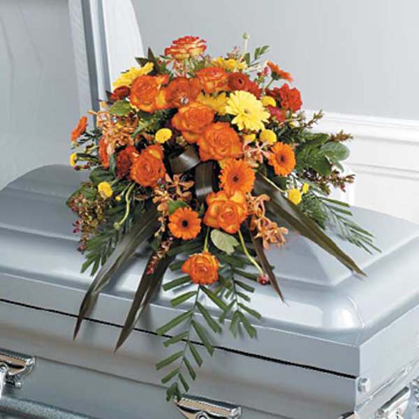 Orange and yellow floral spray on a silver casket