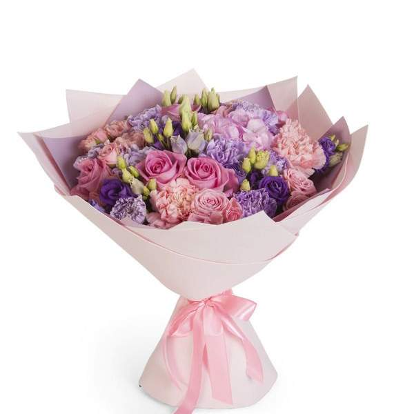 Bouquet of pink, purple, and lavender flowers wrapped in pale pink paper