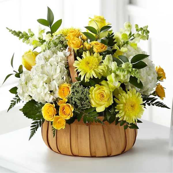 Yellow and white flower arrangement in a woven basket