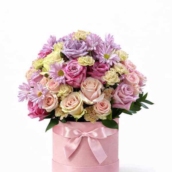 Pink and lavender roses with daisies in a pink hat box