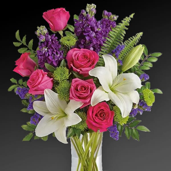 Bouquet of pink roses and white lilies in a clear glass vase