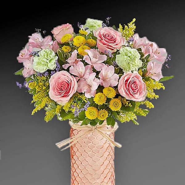 Pink and yellow flower arrangement in a textured vase