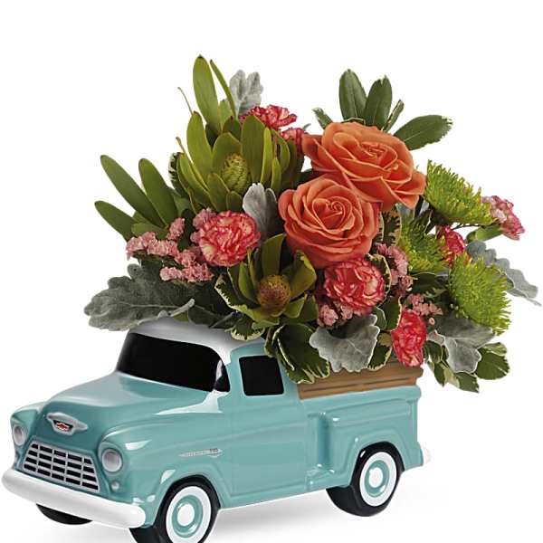 Flower arrangement in a turquoise ceramic truck planter