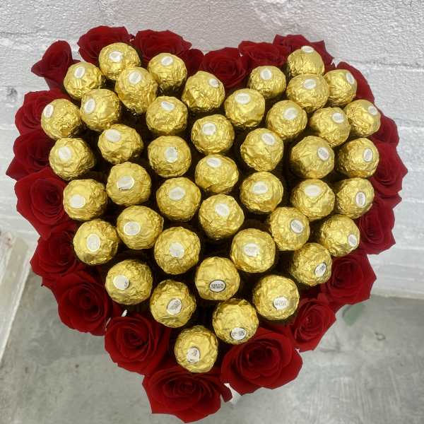 Heart-shaped bouquet of red roses with gold-wrapped chocolates