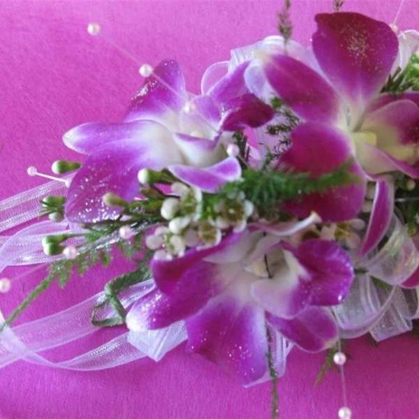 Purple orchid corsage with white ribbon and pearl accents
