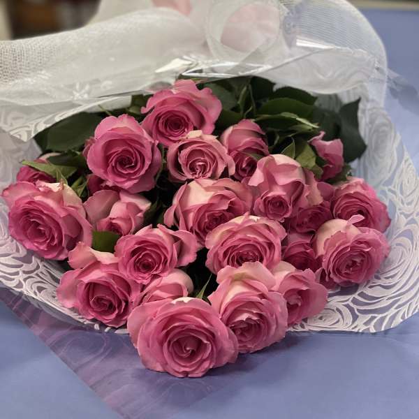 Bouquet of pink roses wrapped in white mesh paper