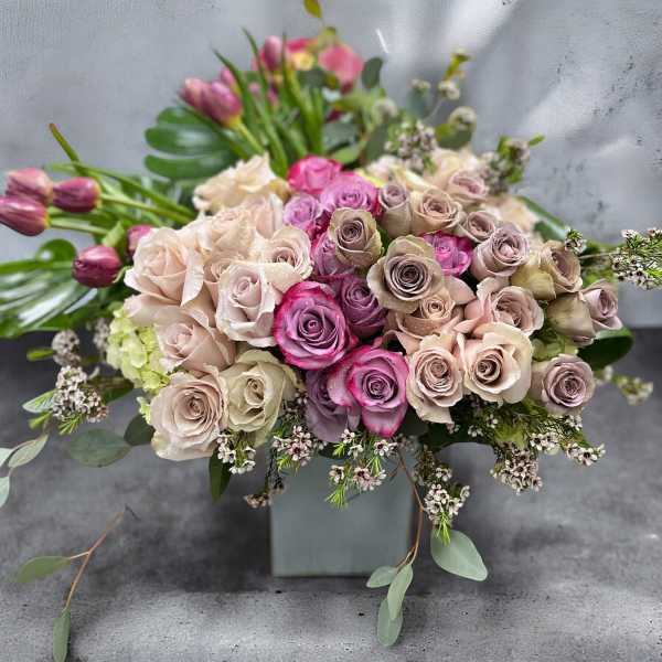 Bouquet of pink and blush roses in a square vase