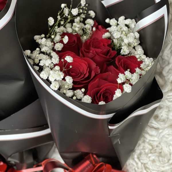 Bouquet of red roses with white baby's breath in black wrapping
