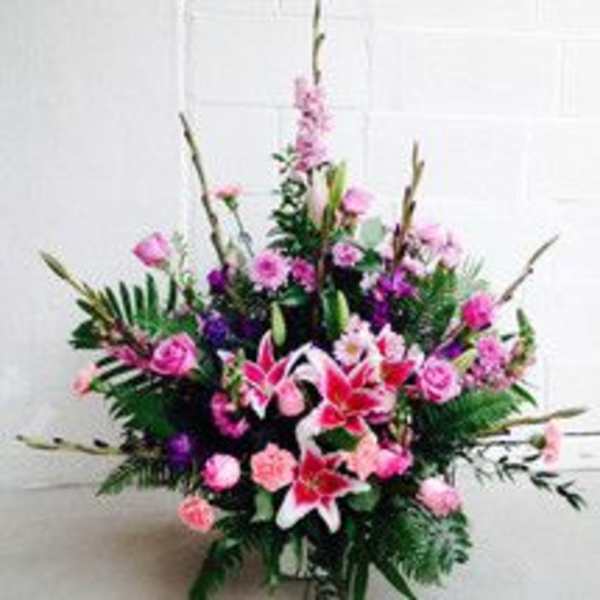 Tall pink and purple floral arrangement with lilies and roses