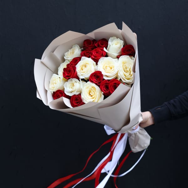 Bouquet of red and white roses wrapped in beige paper with red and white ribbons