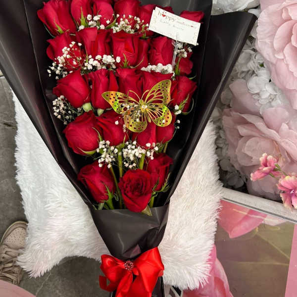 Bouquet of red roses in black wrap with a red ribbon