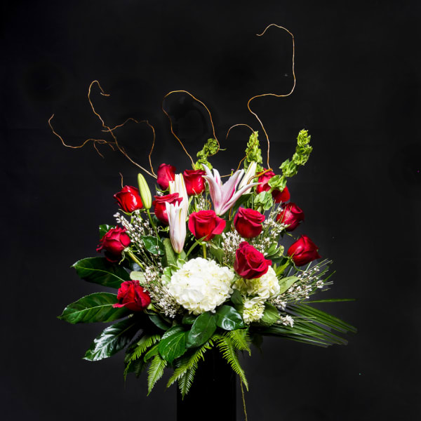 Red roses and white lilies arranged in a tall black vase