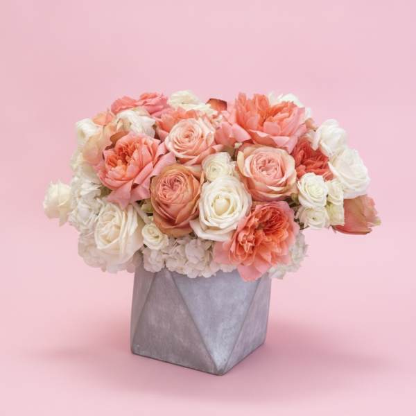 Peach and white rose arrangement in a gray geometric vase