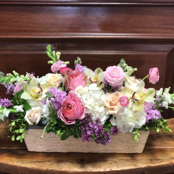 Low floral centerpiece with pink and white blooms in a rectangular basket