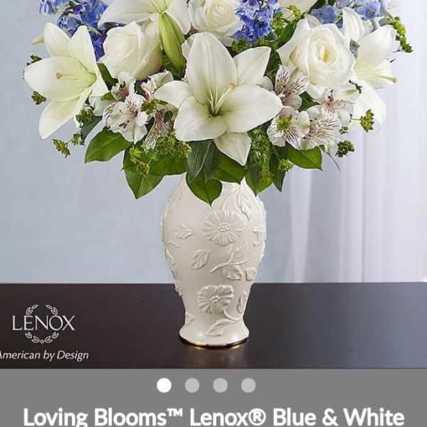 White lilies and roses with blue flowers in a decorative vase