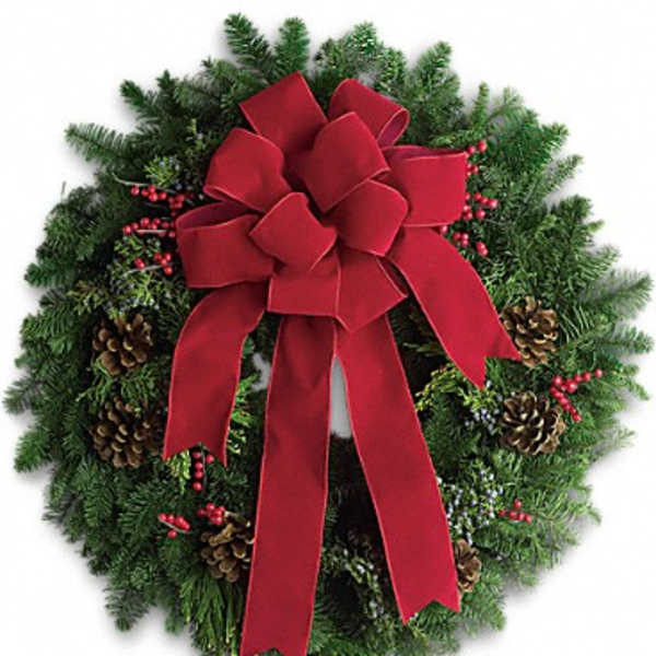 Evergreen holiday wreath with a large red bow and pinecones