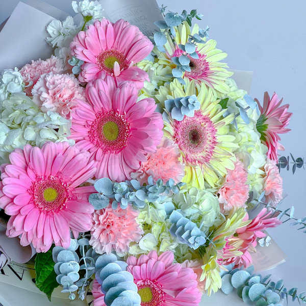 Bouquet of pink and pale yellow gerbera daisies with white blooms