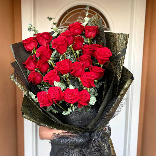 Bouquet of red roses wrapped in black and gold paper