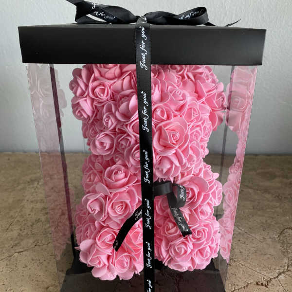 Pink rose-shaped arrangement in a clear gift box with a black ribbon