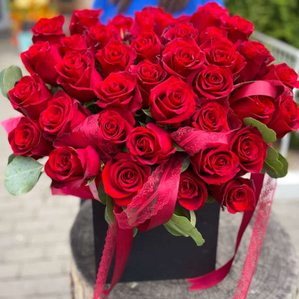 Bouquet of red roses with pink ribbon in a black box