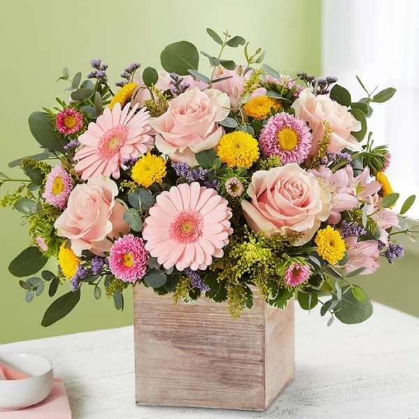 Pink roses and daisies in a wooden box arrangement