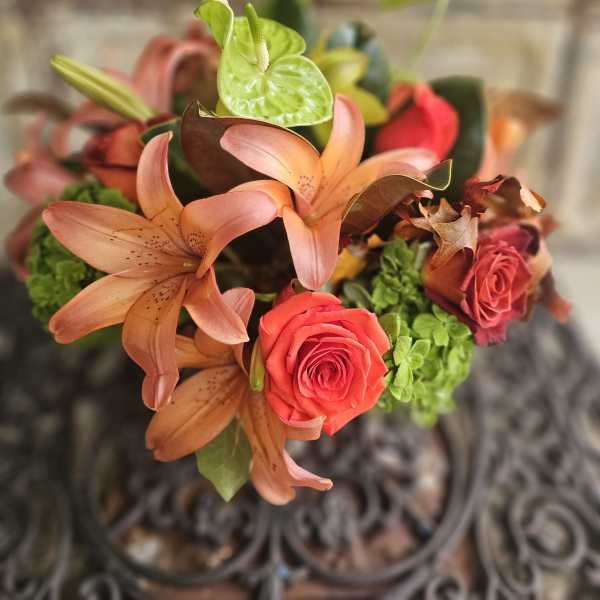 Bouquet of peach lilies, red roses, and green anthuriums