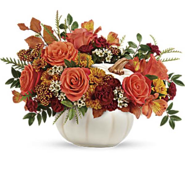 Autumn floral arrangement in a white pumpkin vase with orange and burgundy blooms