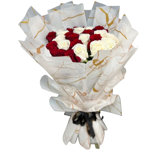 Bouquet of red and white roses wrapped in white paper with gold accents