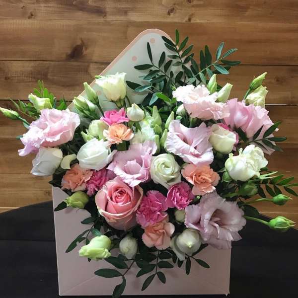 Pink and white bouquet with roses and ruffled blooms in a pale box