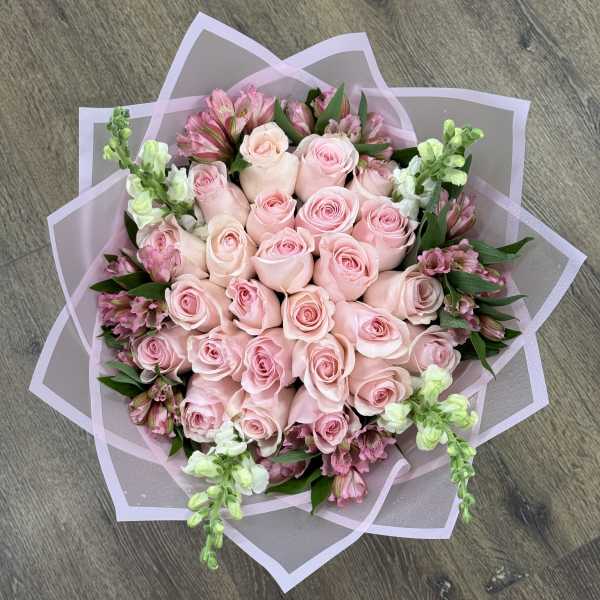 Bouquet of pale pink roses with pink and white accent flowers