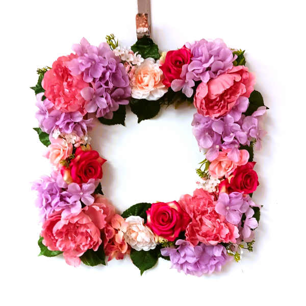 Floral wreath with pink, purple, and red blooms on a white background