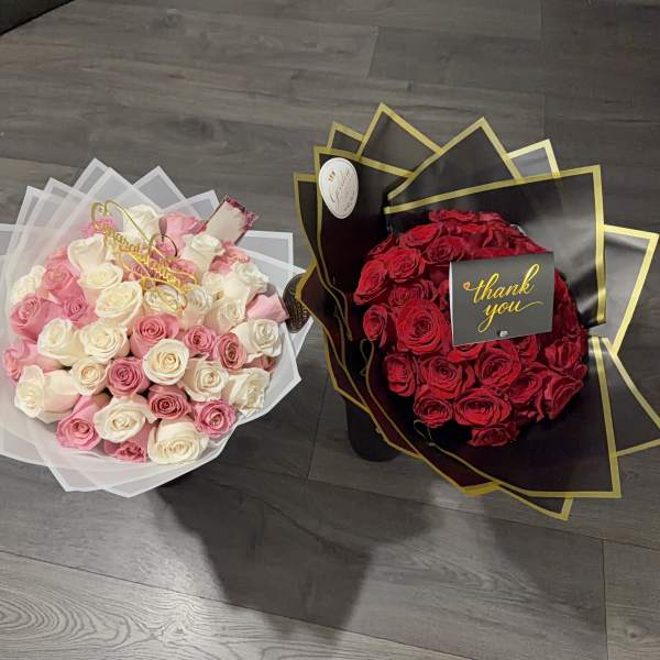 Two rose bouquets, one pink and white and one red, wrapped in decorative paper