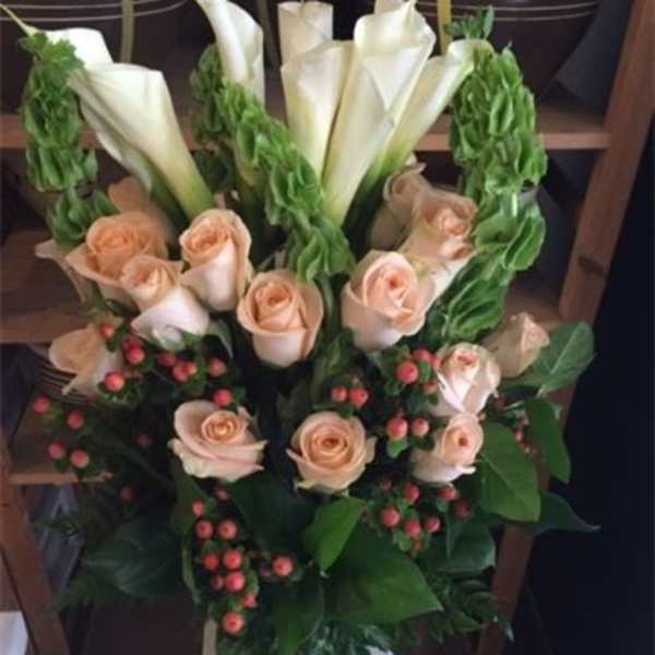 Bouquet of peach roses and white calla lilies with red berries
