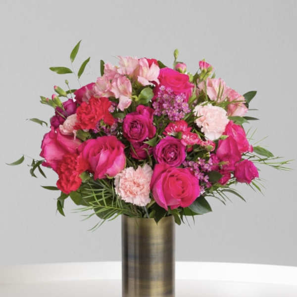 Pink and magenta bouquet in a tall gold vase